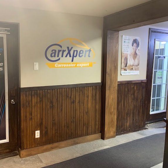 Mur du bureau CarrXpert avec logo, lambris et entrée du couloir