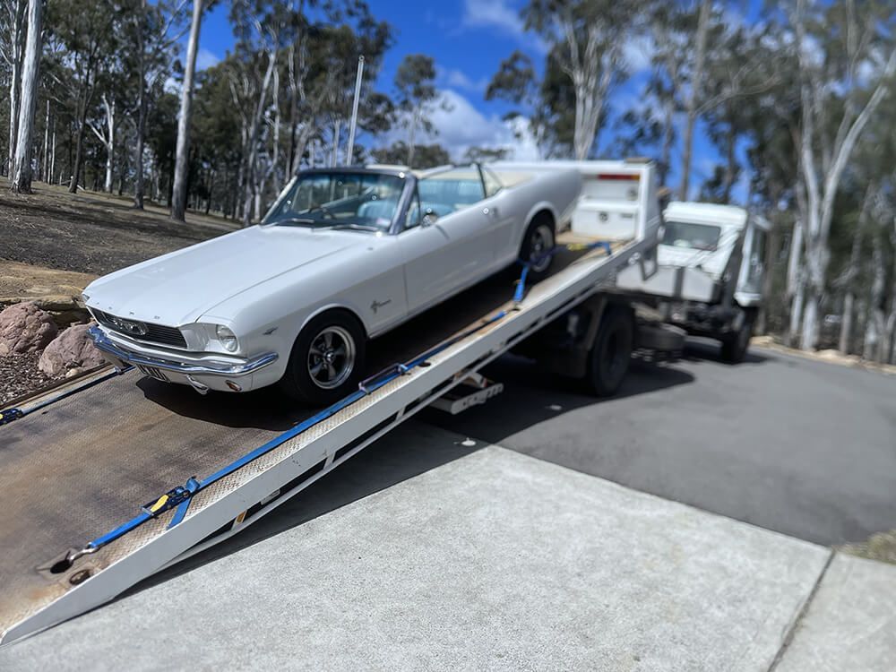 Unloading White Mustang — Big Tim's Towing in Cessnock, NSW