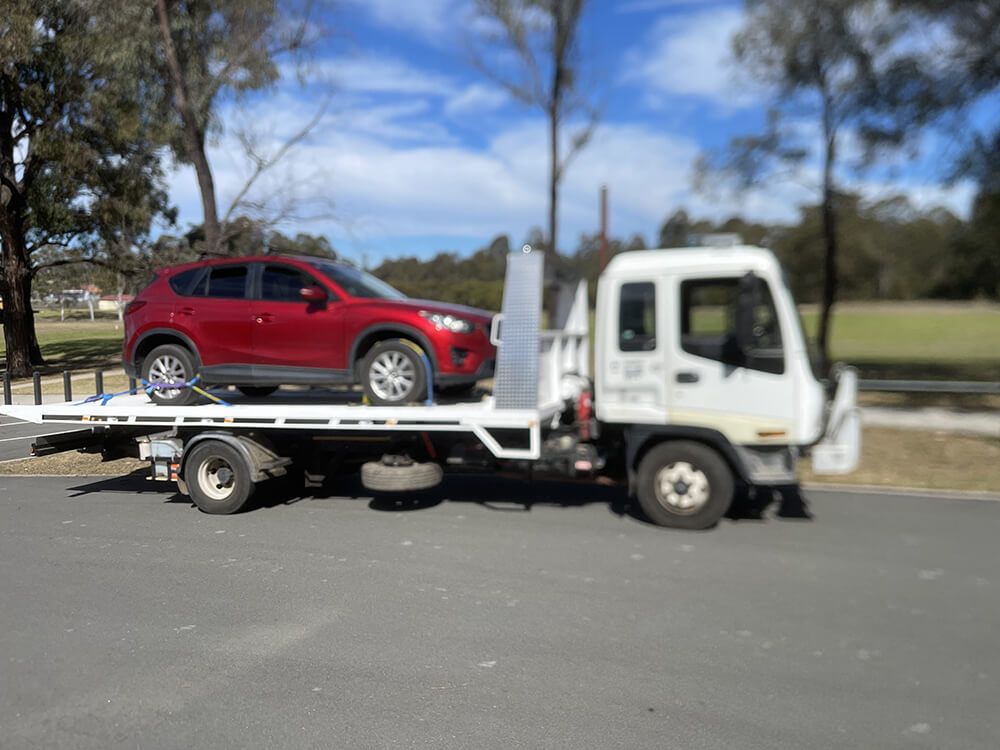 Red Car On The Back Of Tow Truck — Big Tim's Towing in Cessnock, NSW