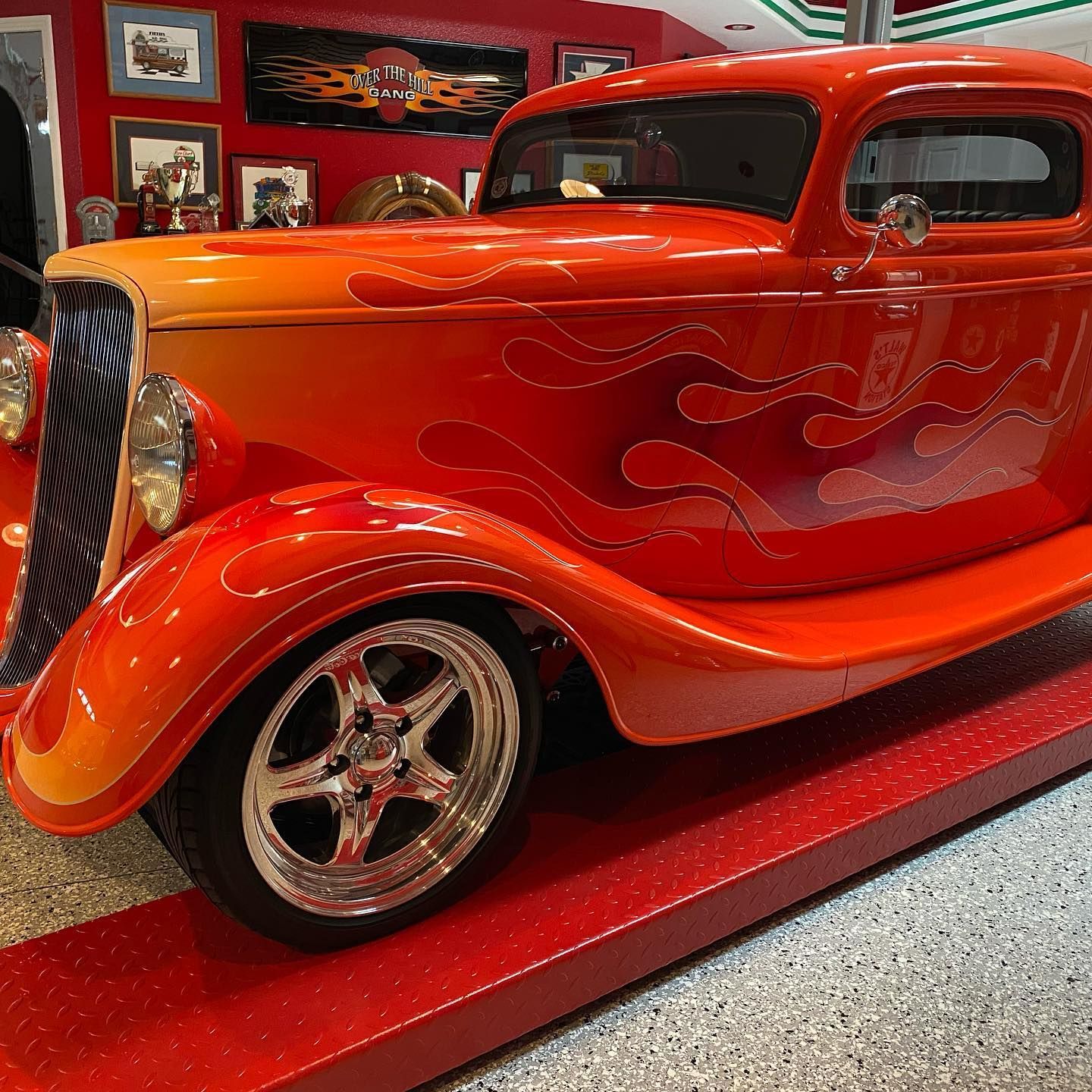 A red car with flames painted on it is on display