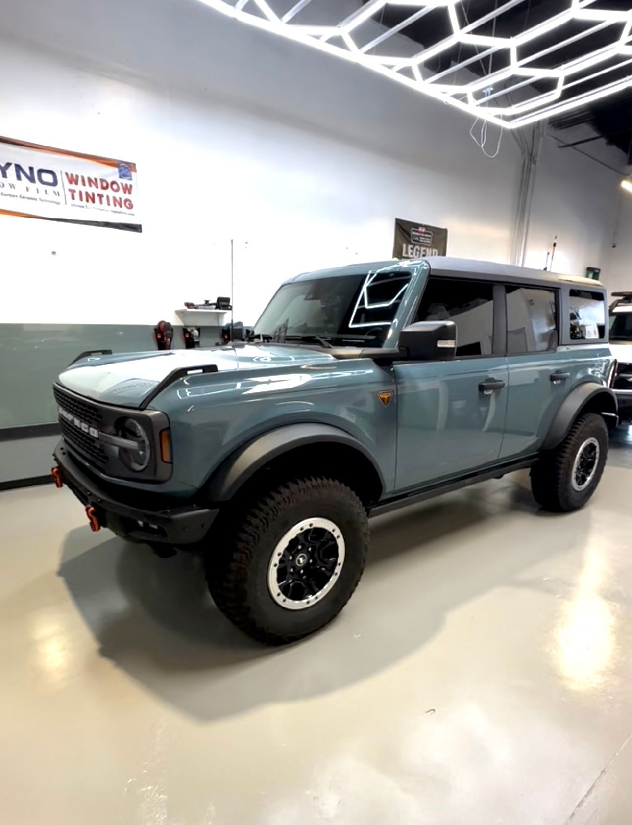 A blue ford bronco is parked in a garage.