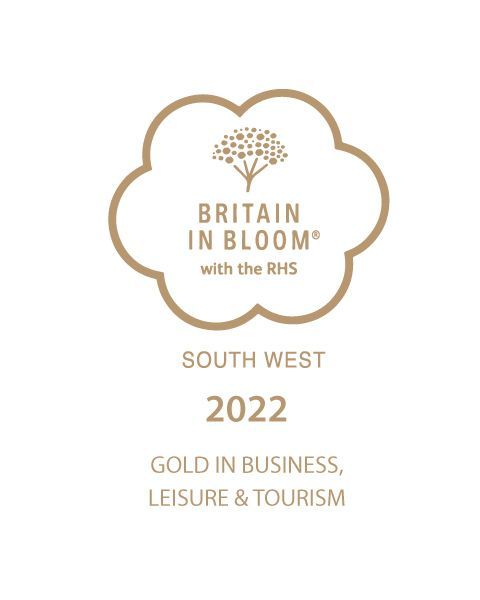 A logo for britain in bloom with the rhs south west 2022