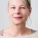 A close up of a woman wearing hoop earrings.