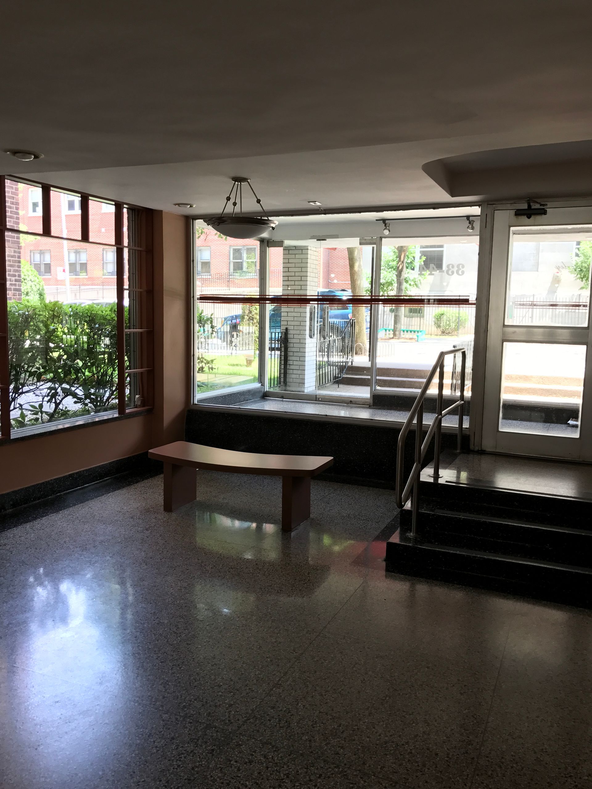 An empty lobby with stairs and a bench