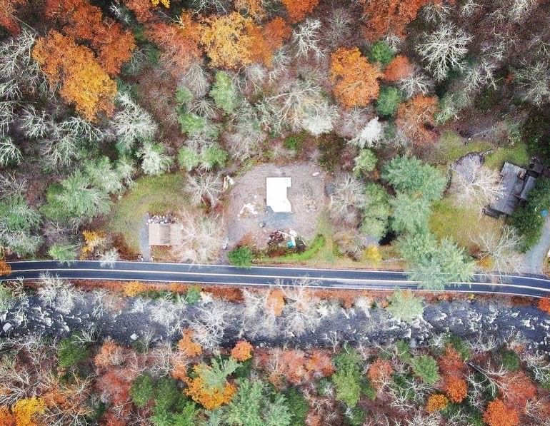 An aerial view of a house in the middle of a forest