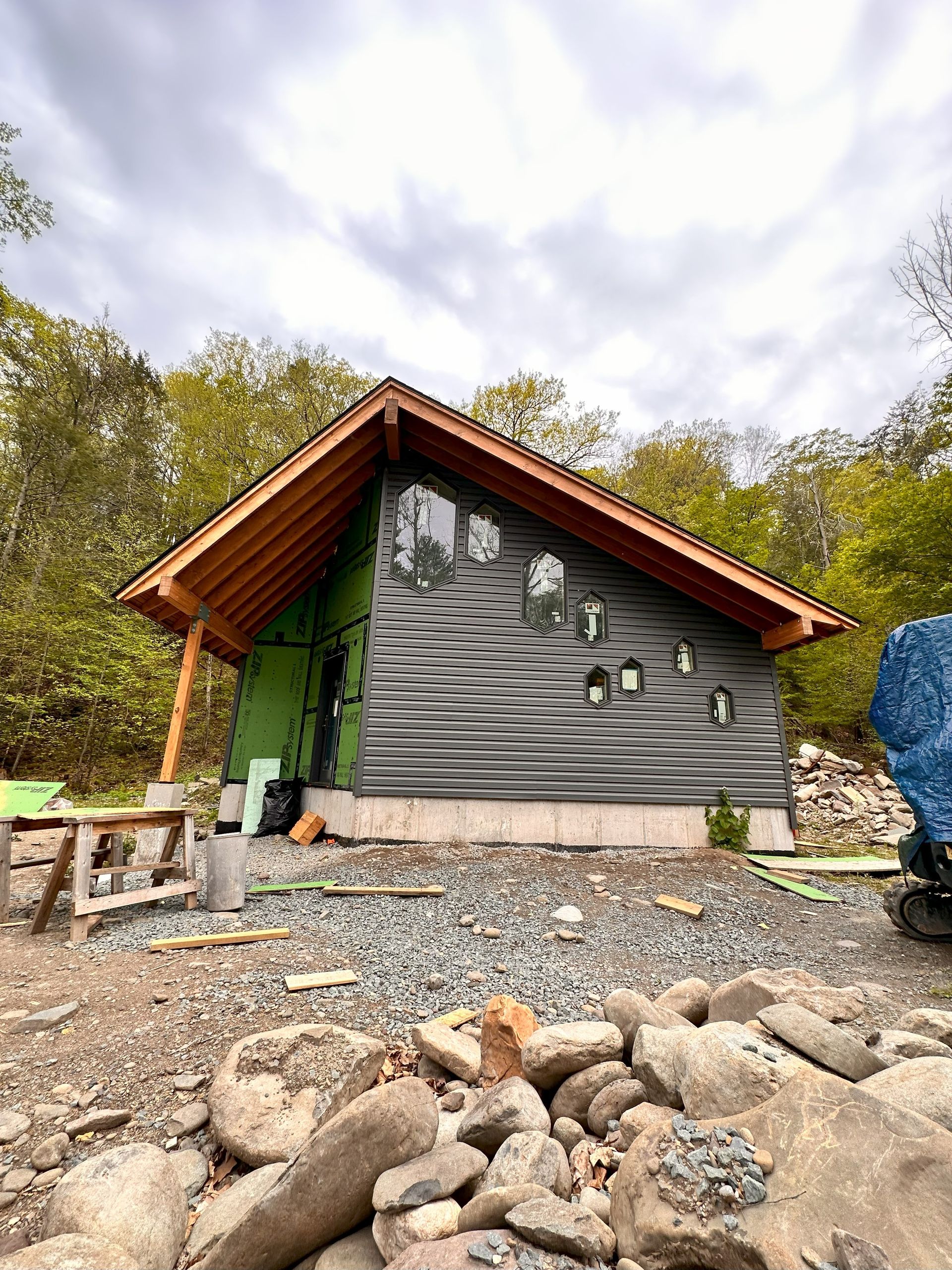 A small house is being built in the middle of a forest.