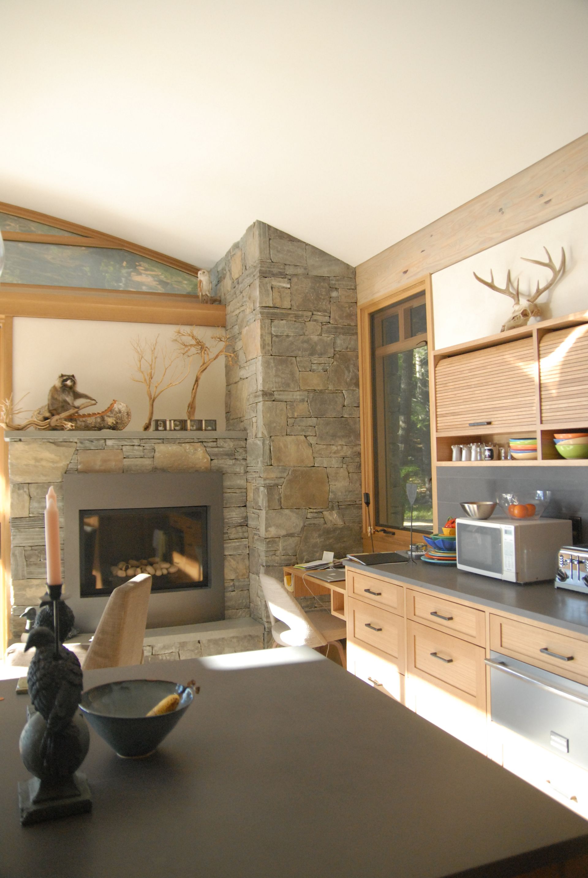 A kitchen with a microwave and a fireplace in the background
