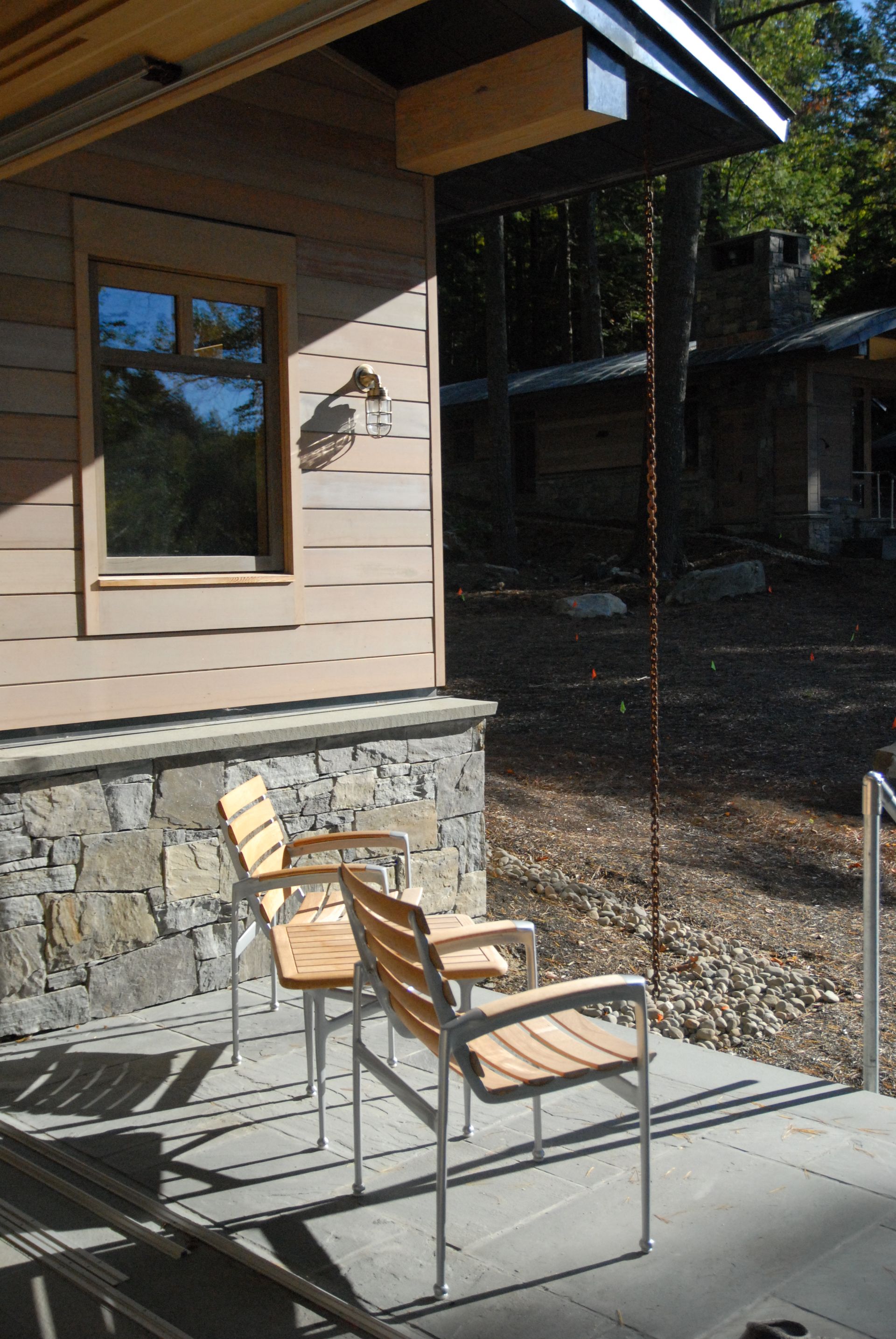 A patio with two chairs and a table in front of a house
