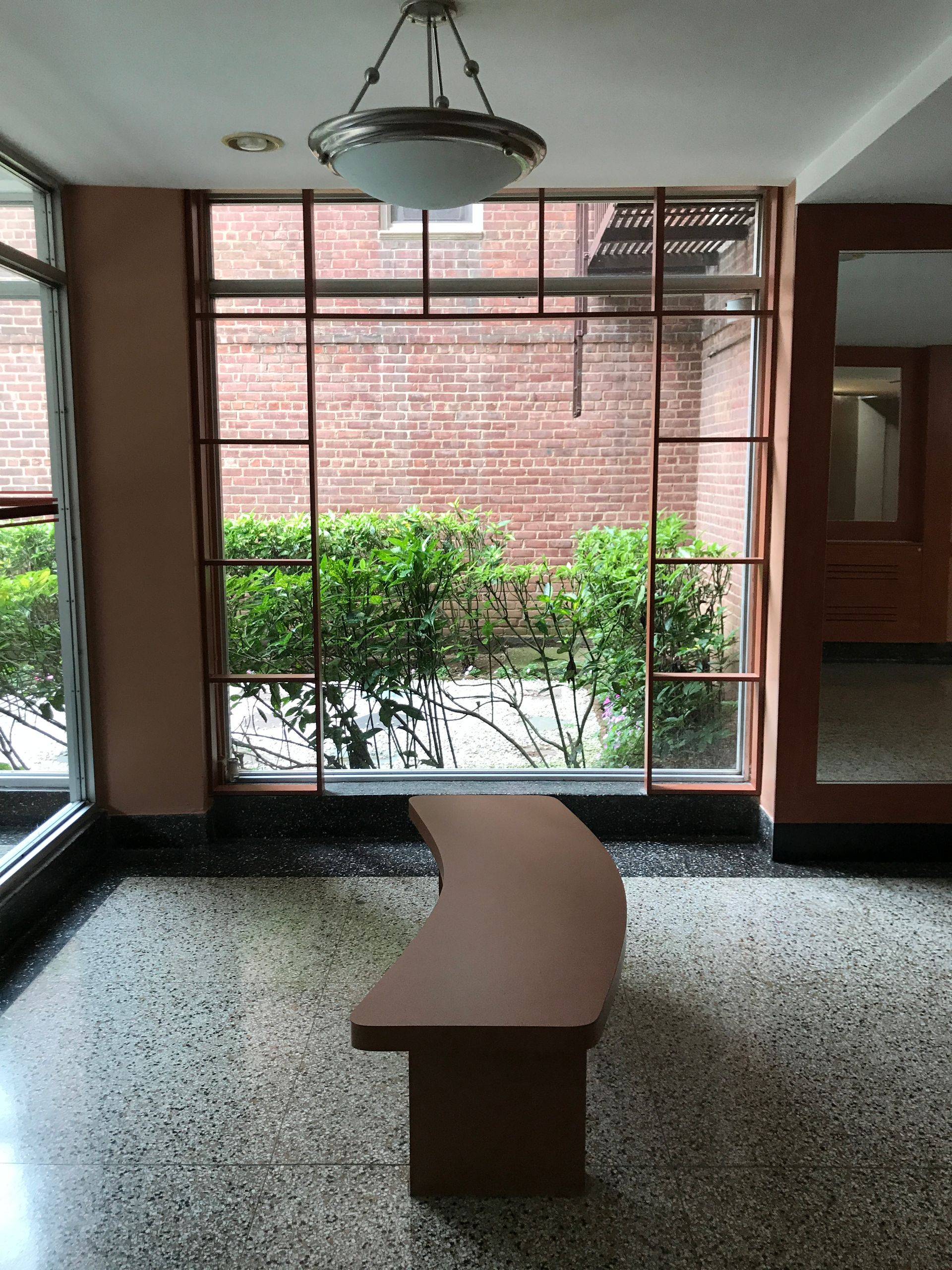 An empty room with a bench and a large window