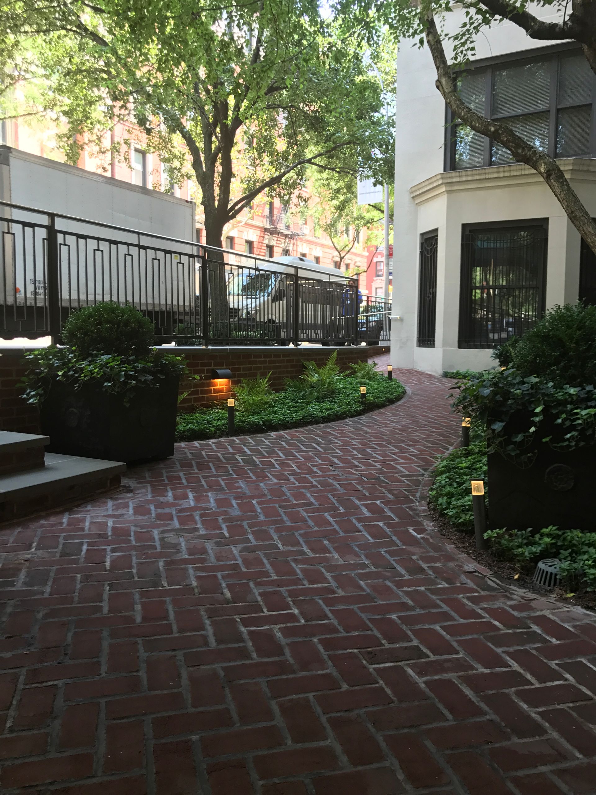 A brick walkway leading to a white building