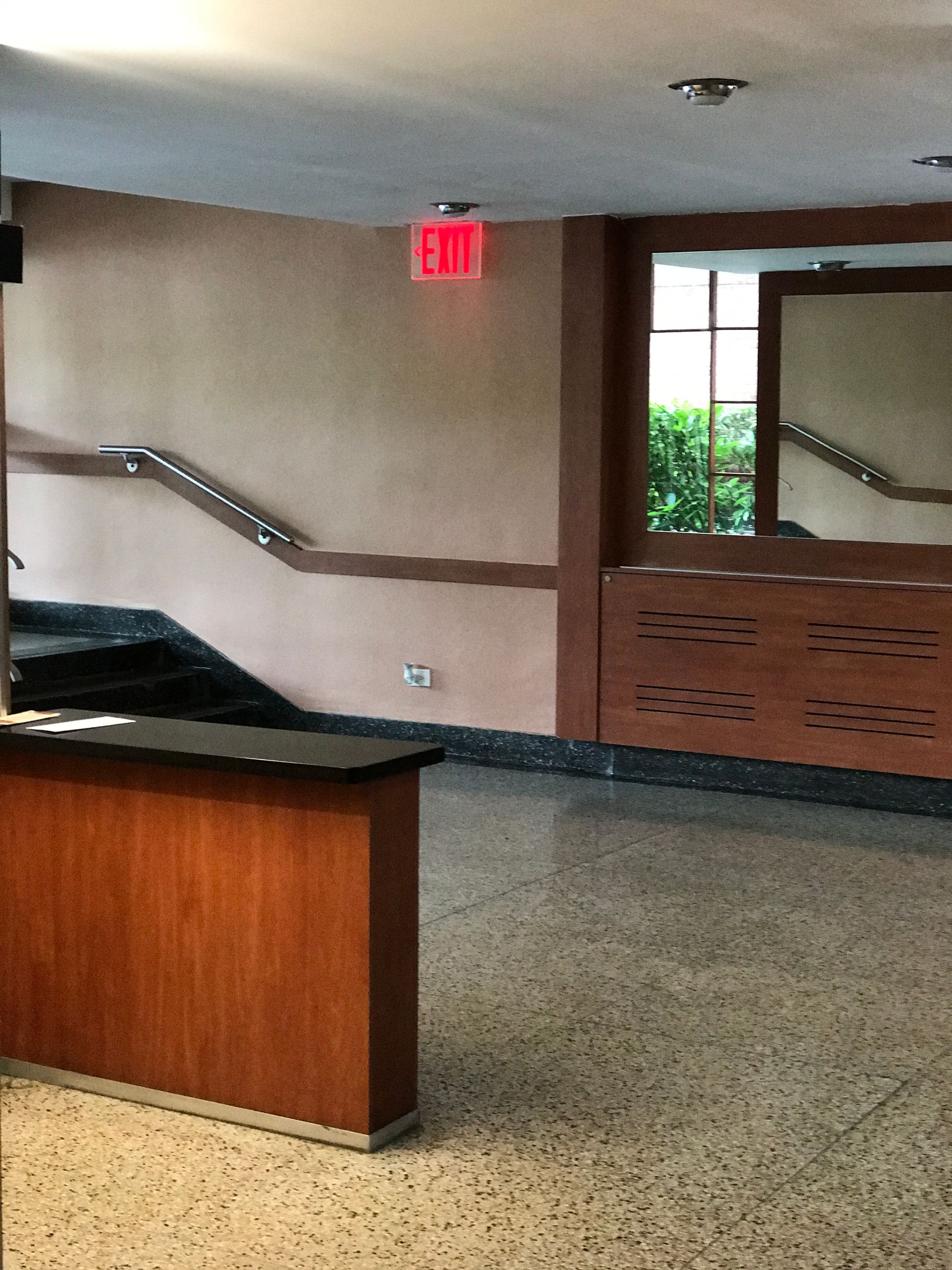 An empty room with a red exit sign on the wall