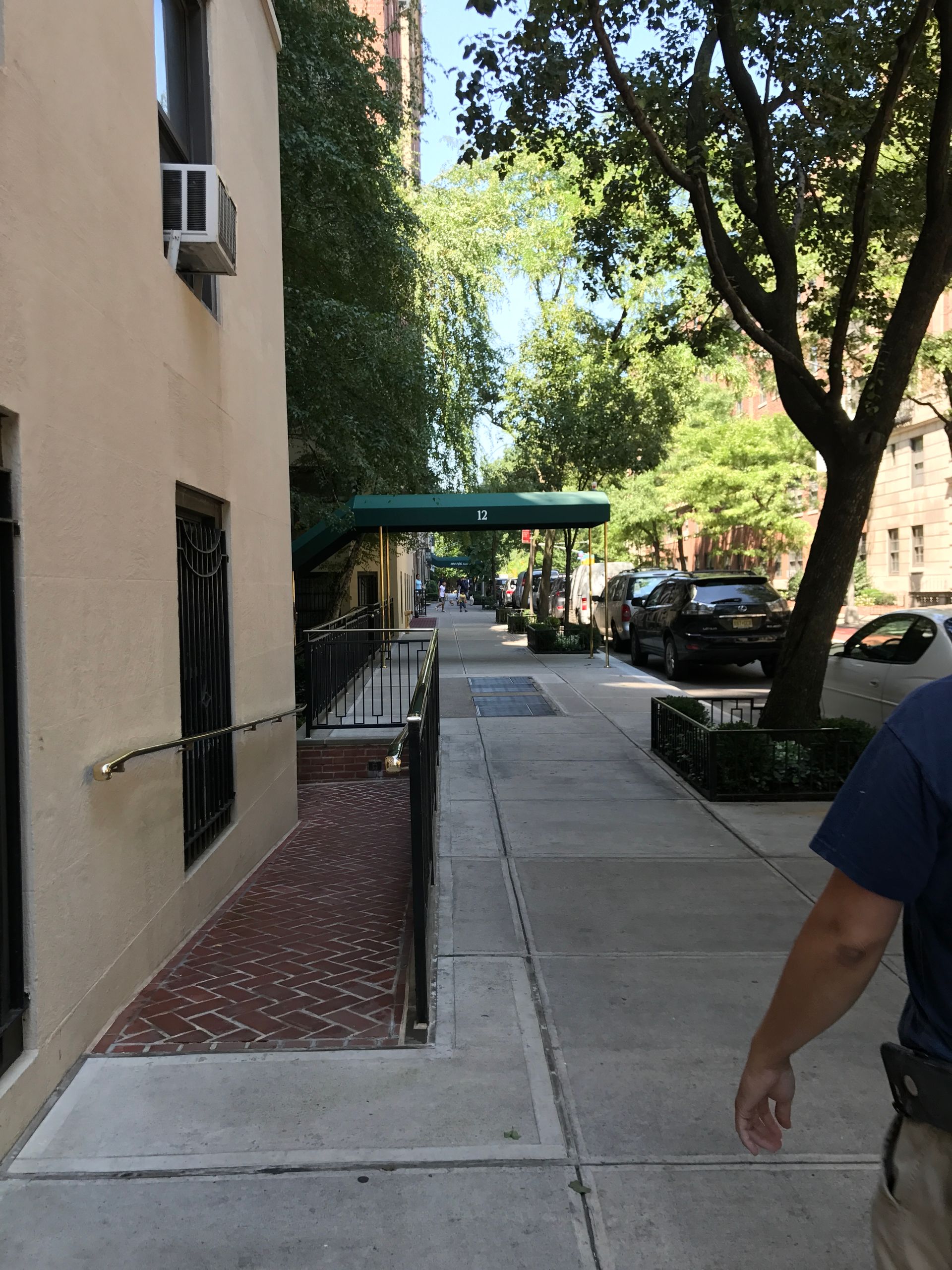 A man is walking down a sidewalk next to a building