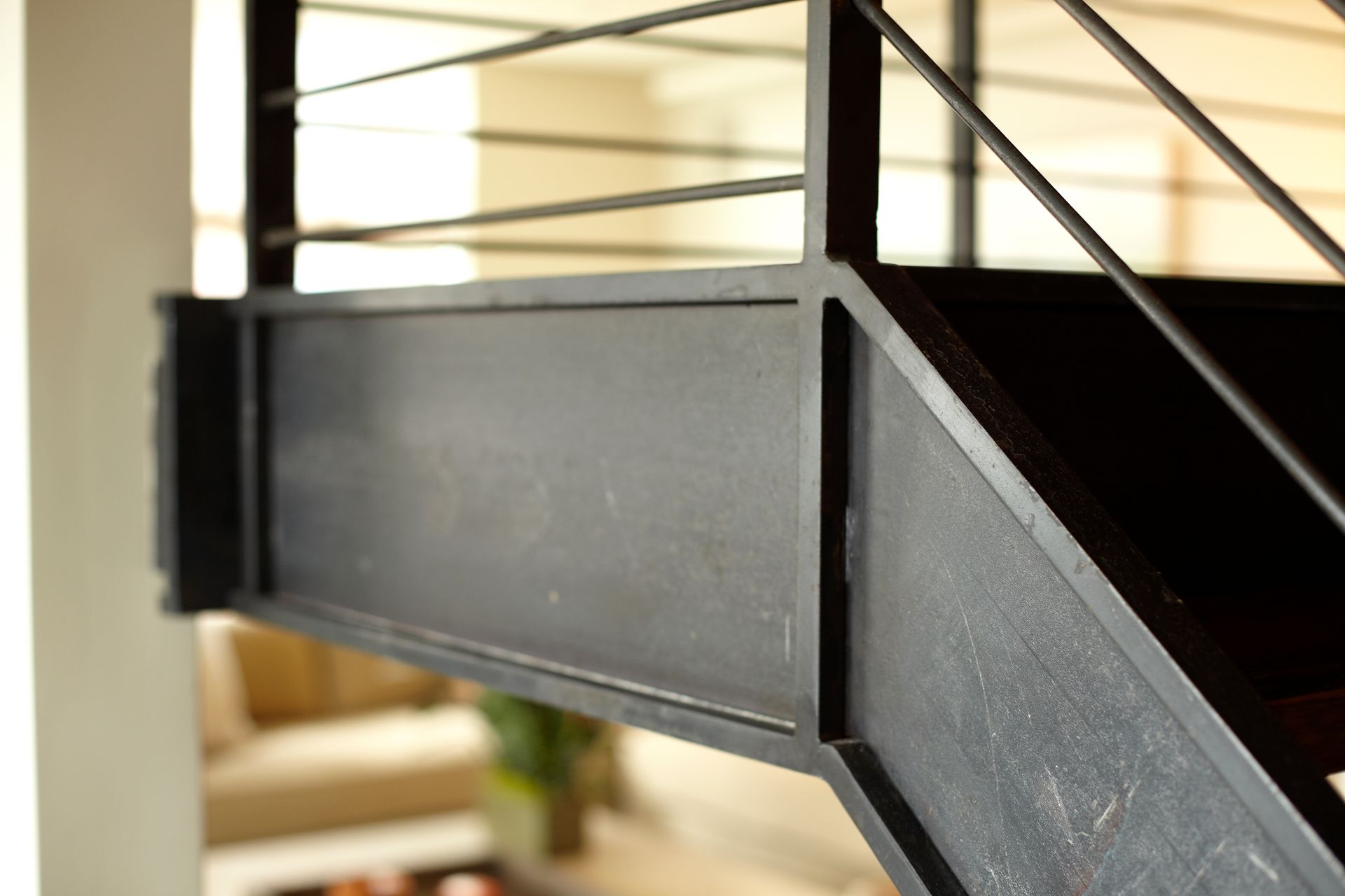 A black staircase with a metal railing in a living room