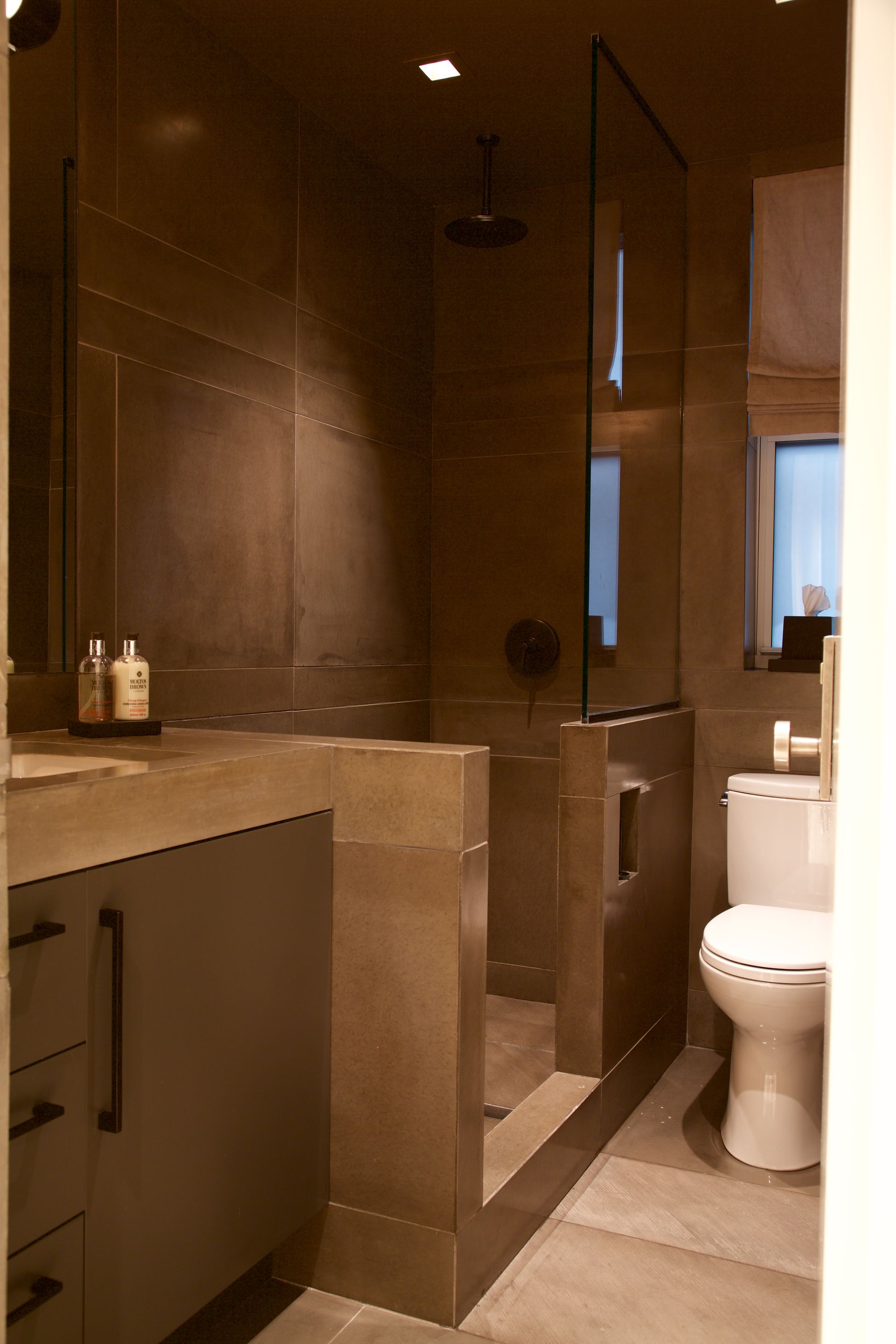 A bathroom with a toilet , sink and shower.
