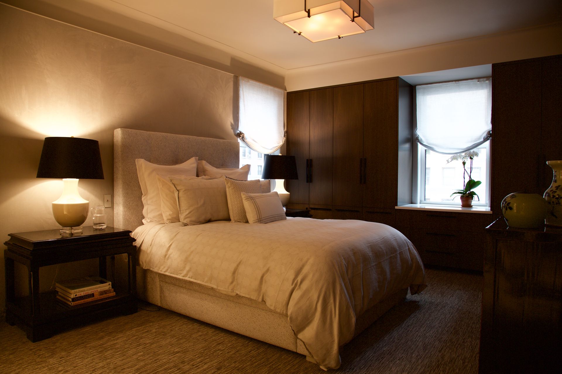 A bedroom with a large bed and two lamps