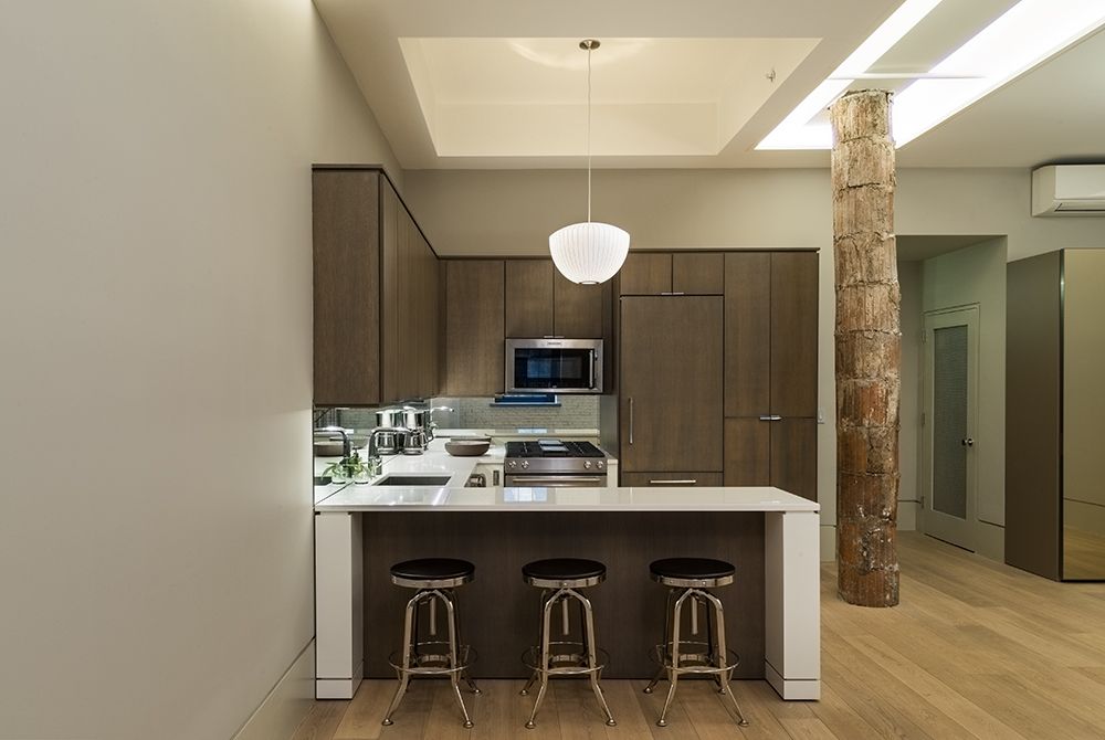A kitchen with stools and a stove top oven