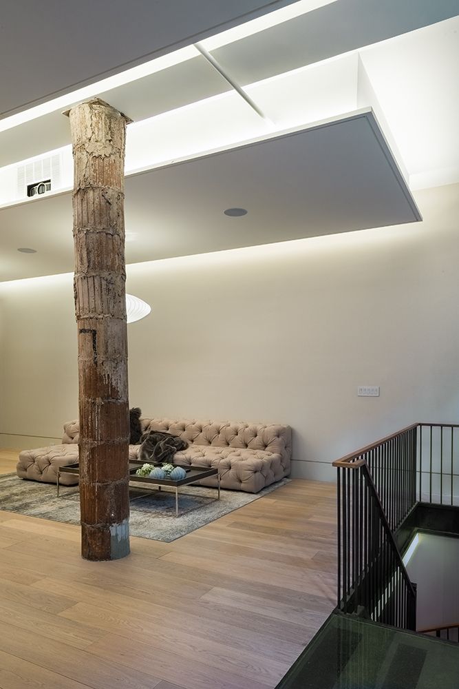 A living room with a couch , coffee table , and stairs.