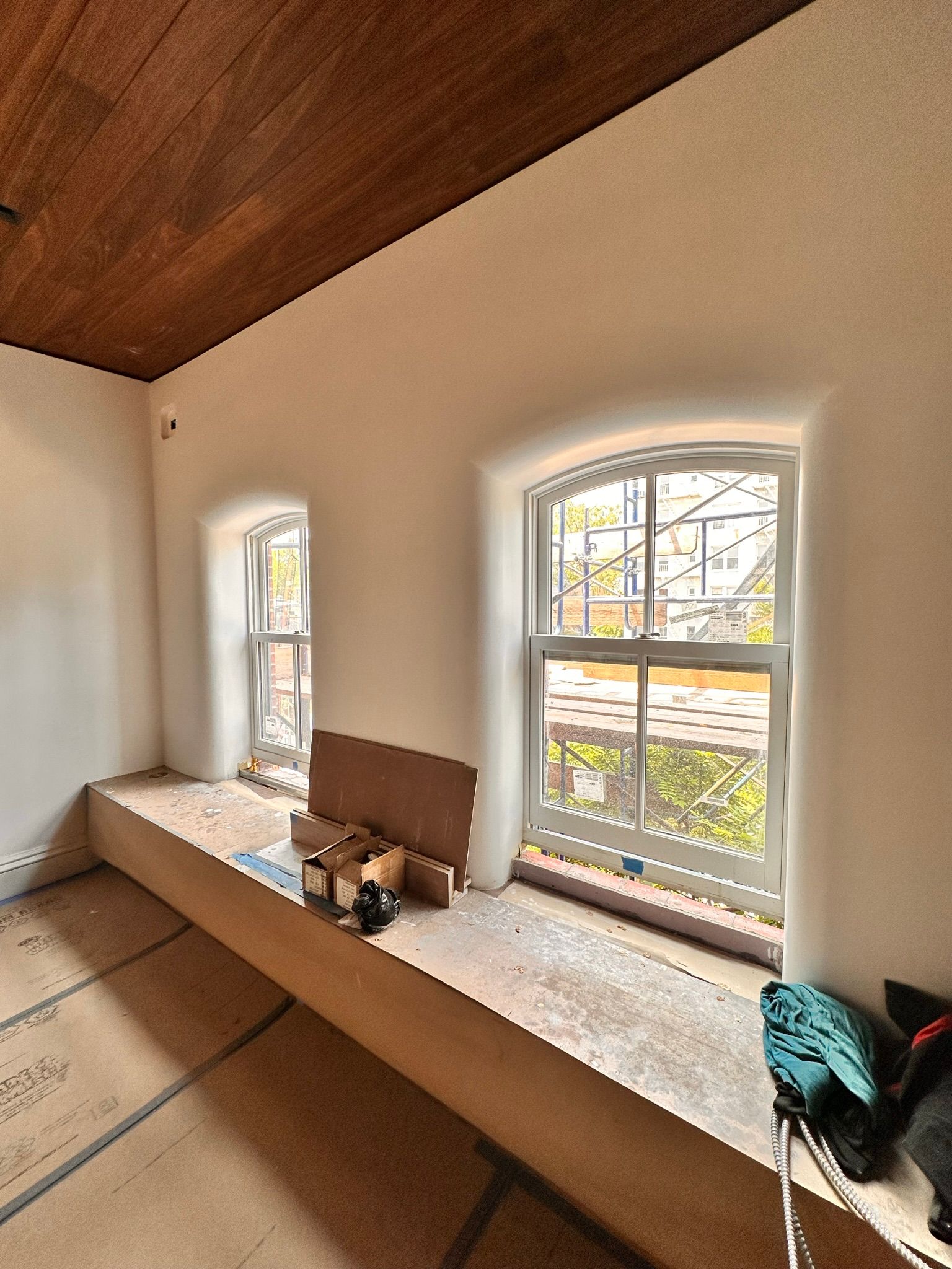 A room with two windows and a wooden ceiling.