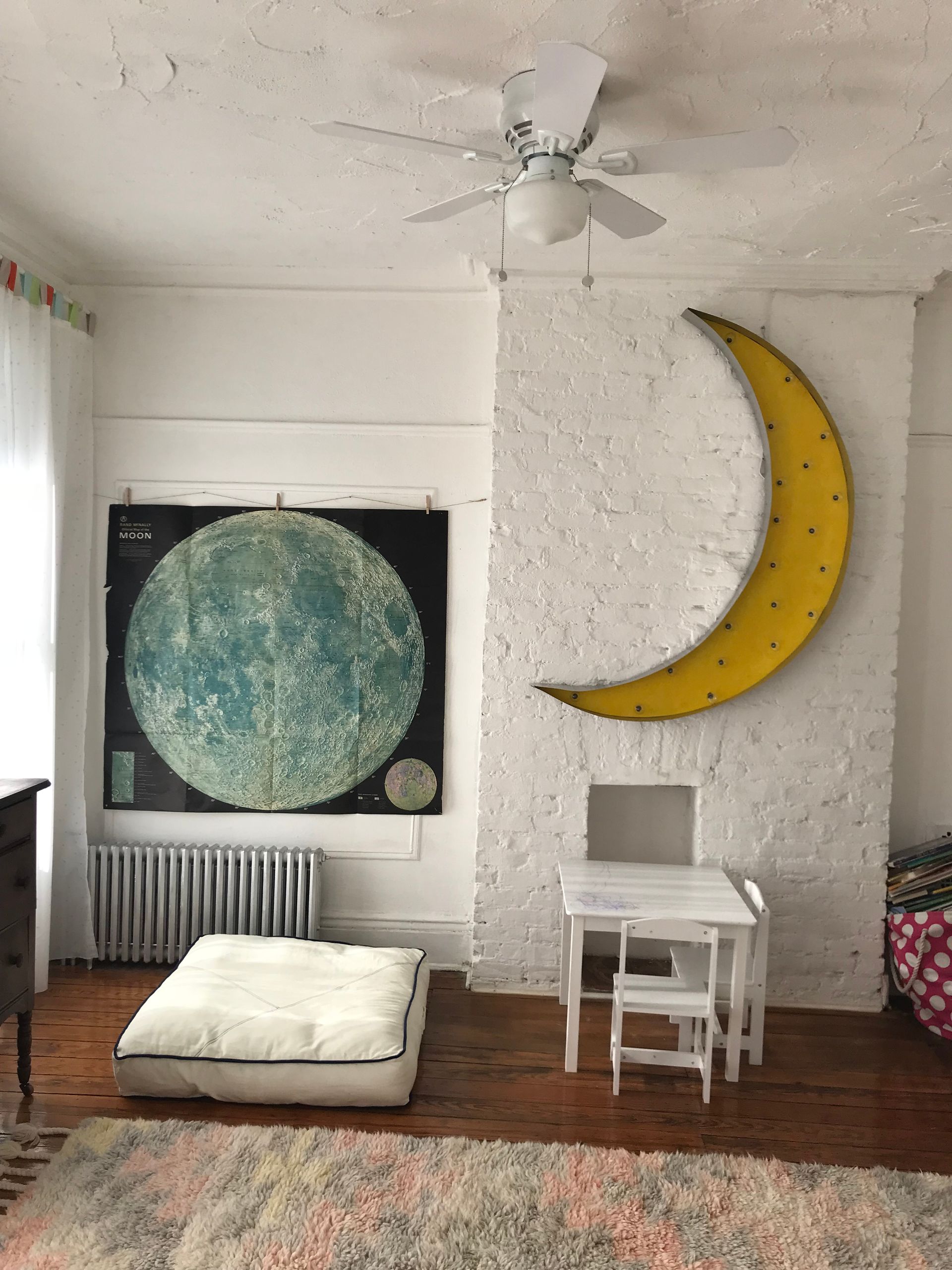A room with a yellow crescent moon on the wall