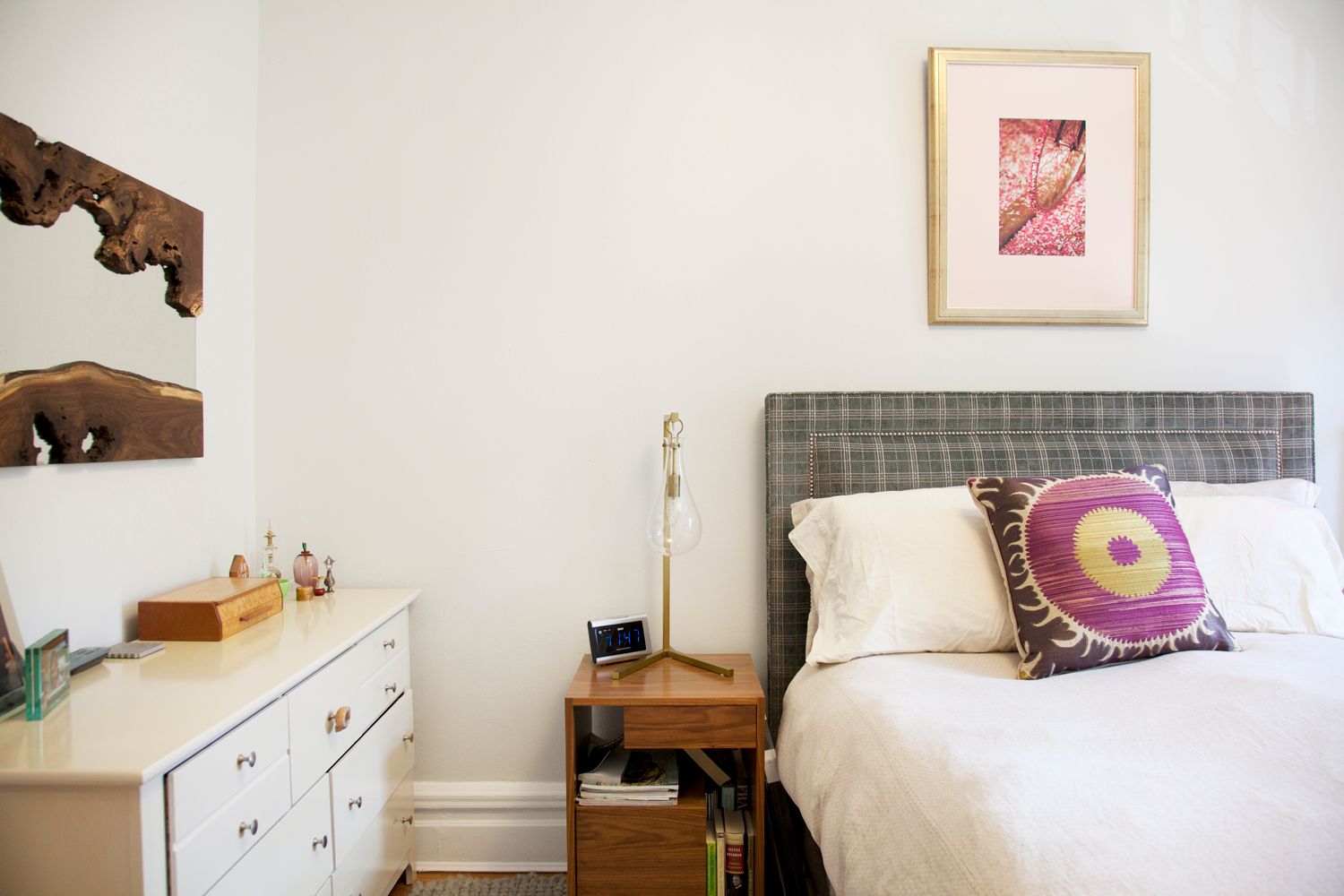 A bedroom with a bed , dresser and nightstand