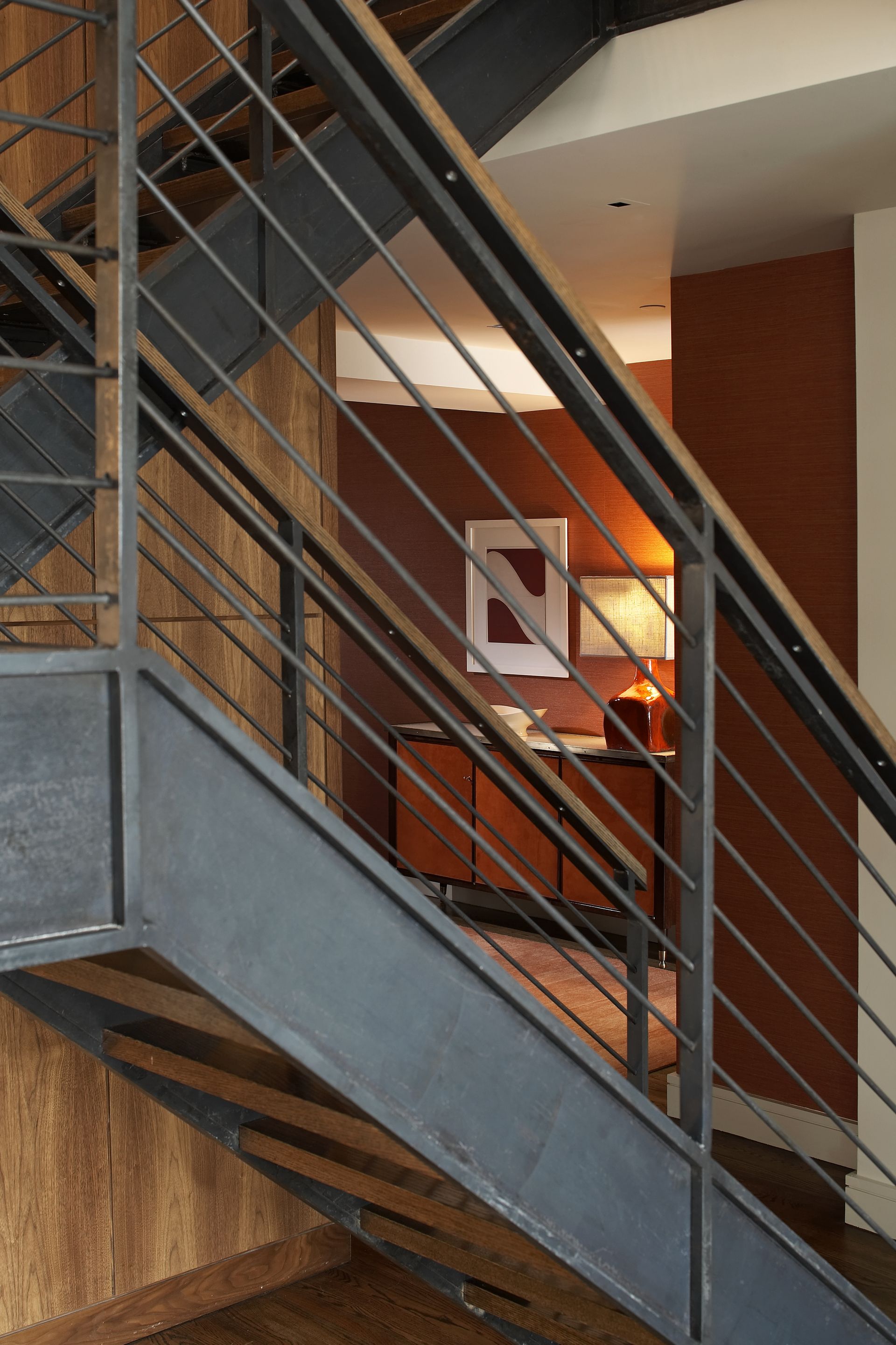 A staircase with a metal railing leading up to a living room