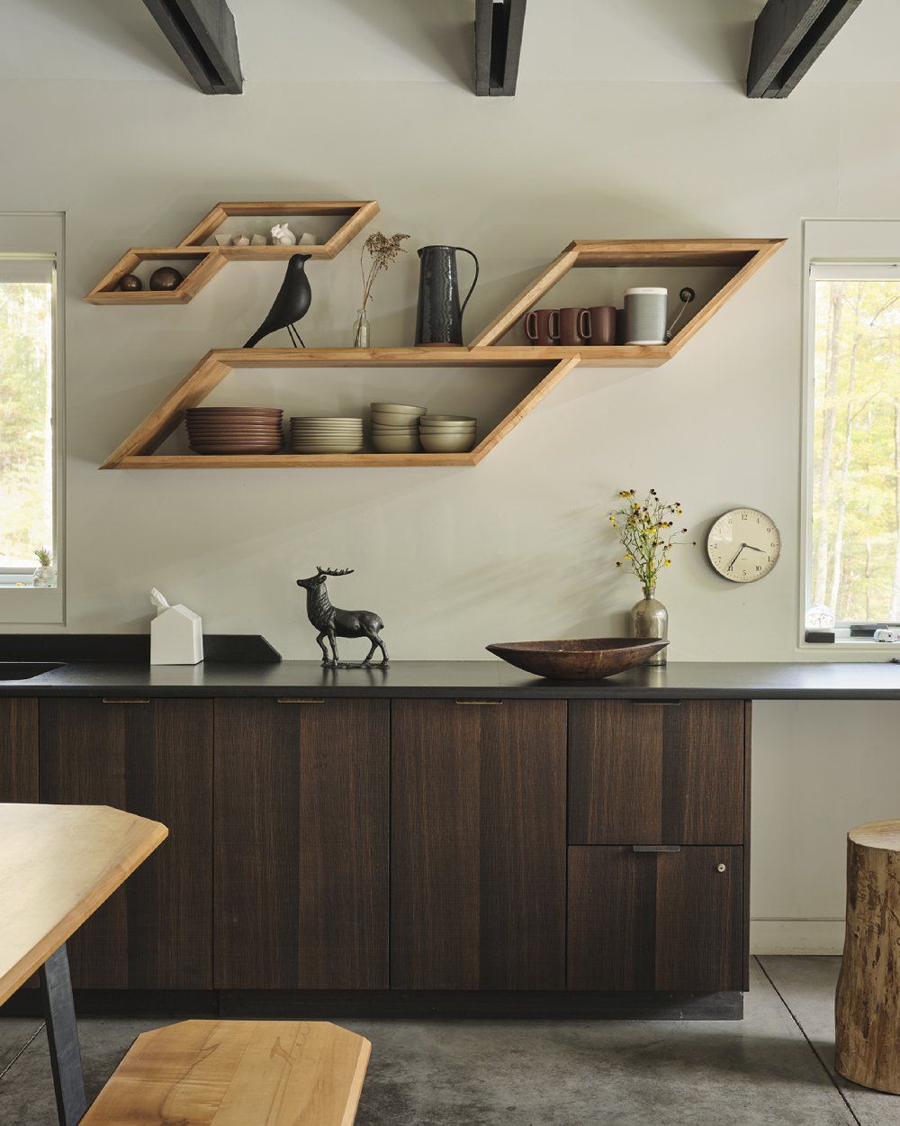 A kitchen with wooden cabinets and a clock on the wall