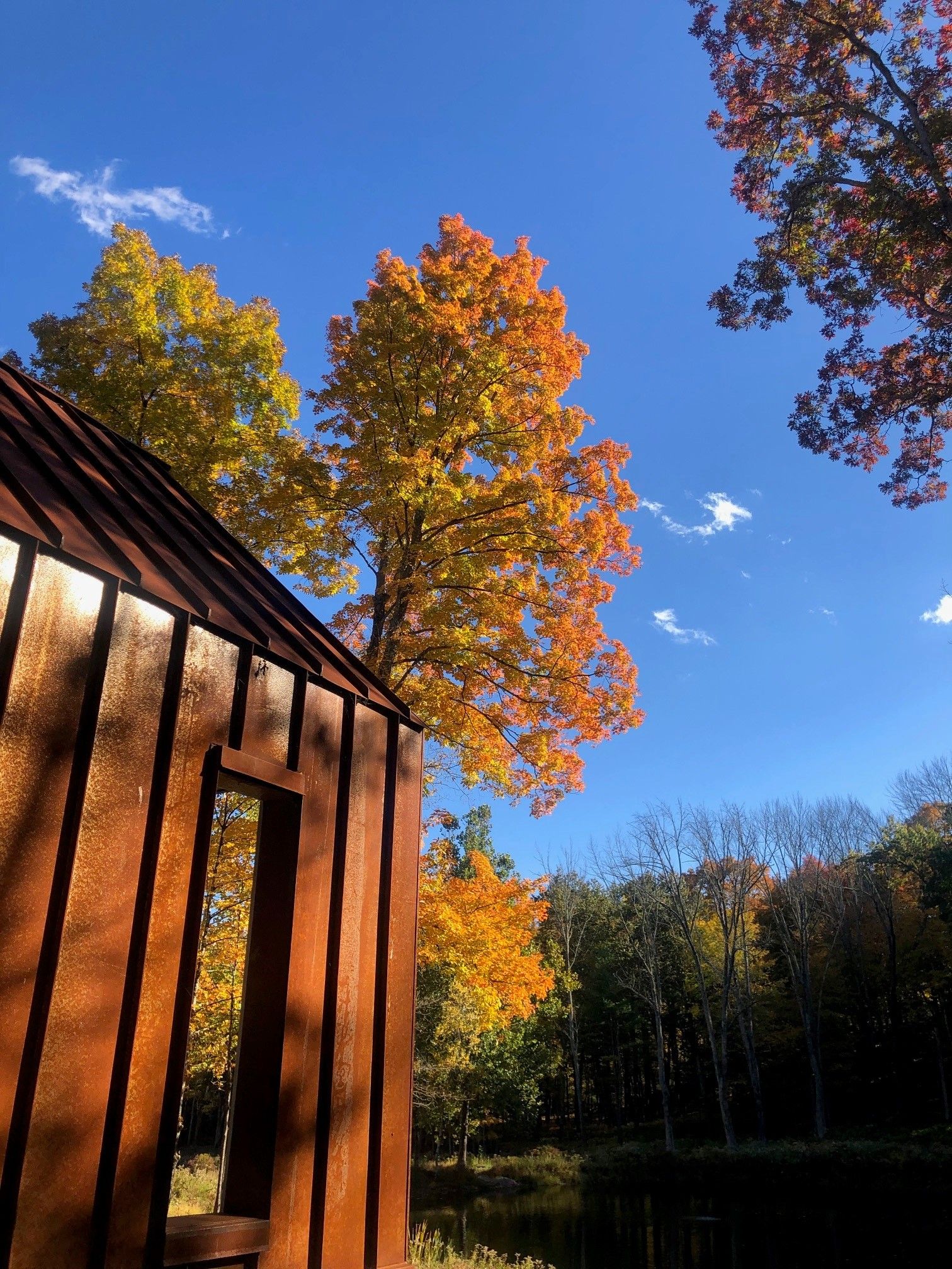 A wooden building with trees in the background and a blue sky