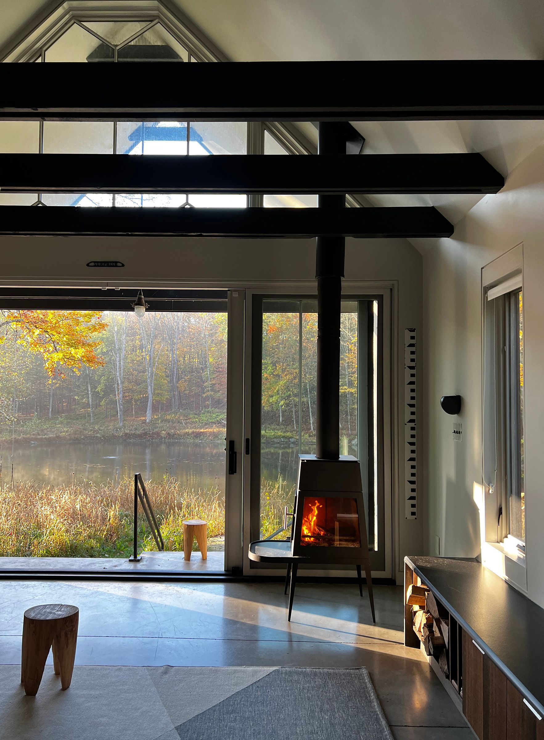 A living room with a fireplace and a view of a river