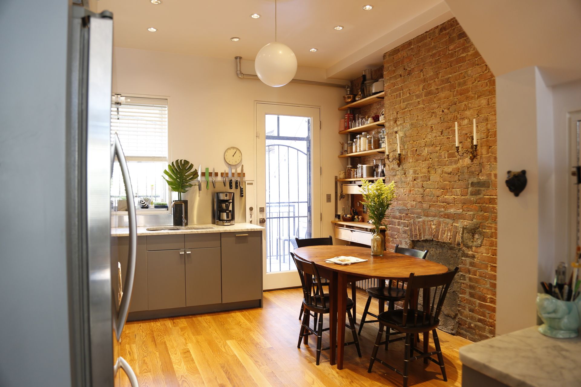 A kitchen with a table and chairs and a brick wall