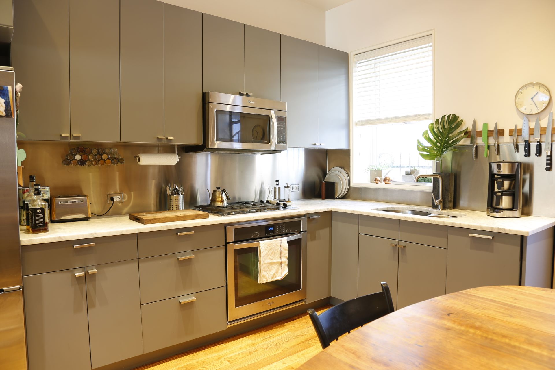 A kitchen with stainless steel appliances and gray cabinets
