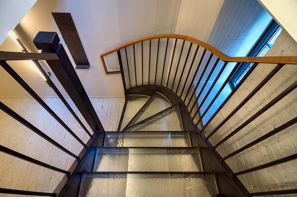 A spiral staircase with a metal railing and a glass floor