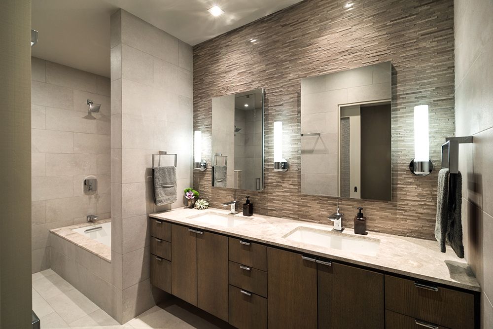 A bathroom with two sinks , two mirrors and a bathtub.