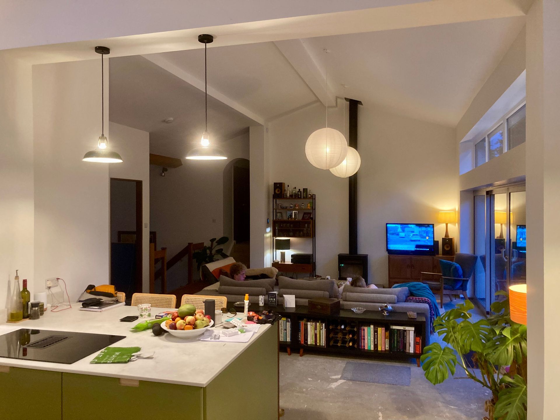 A kitchen with green cabinets and a stove top oven in a living room.