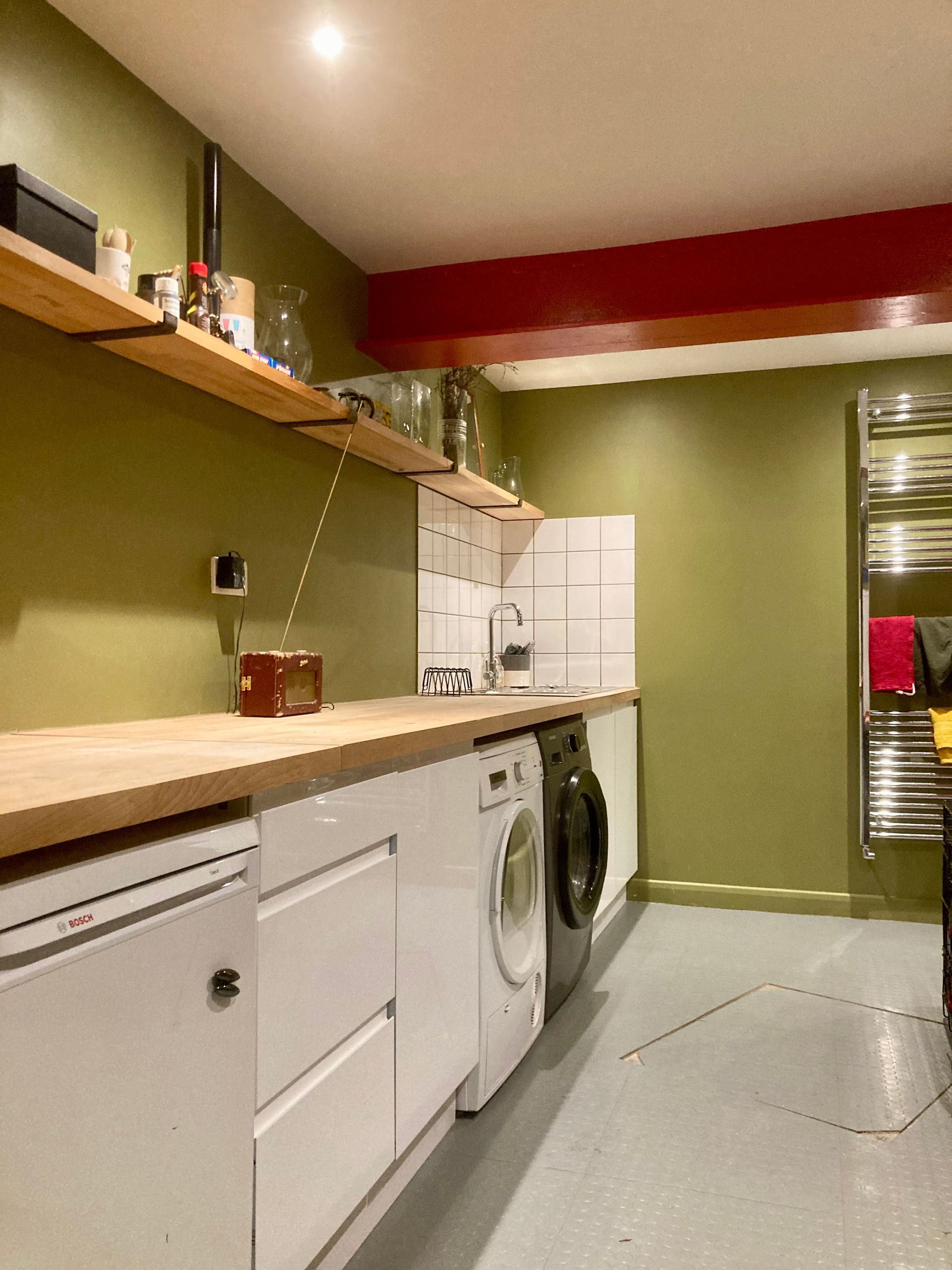 A kitchen with white cabinets and a washer and dryer