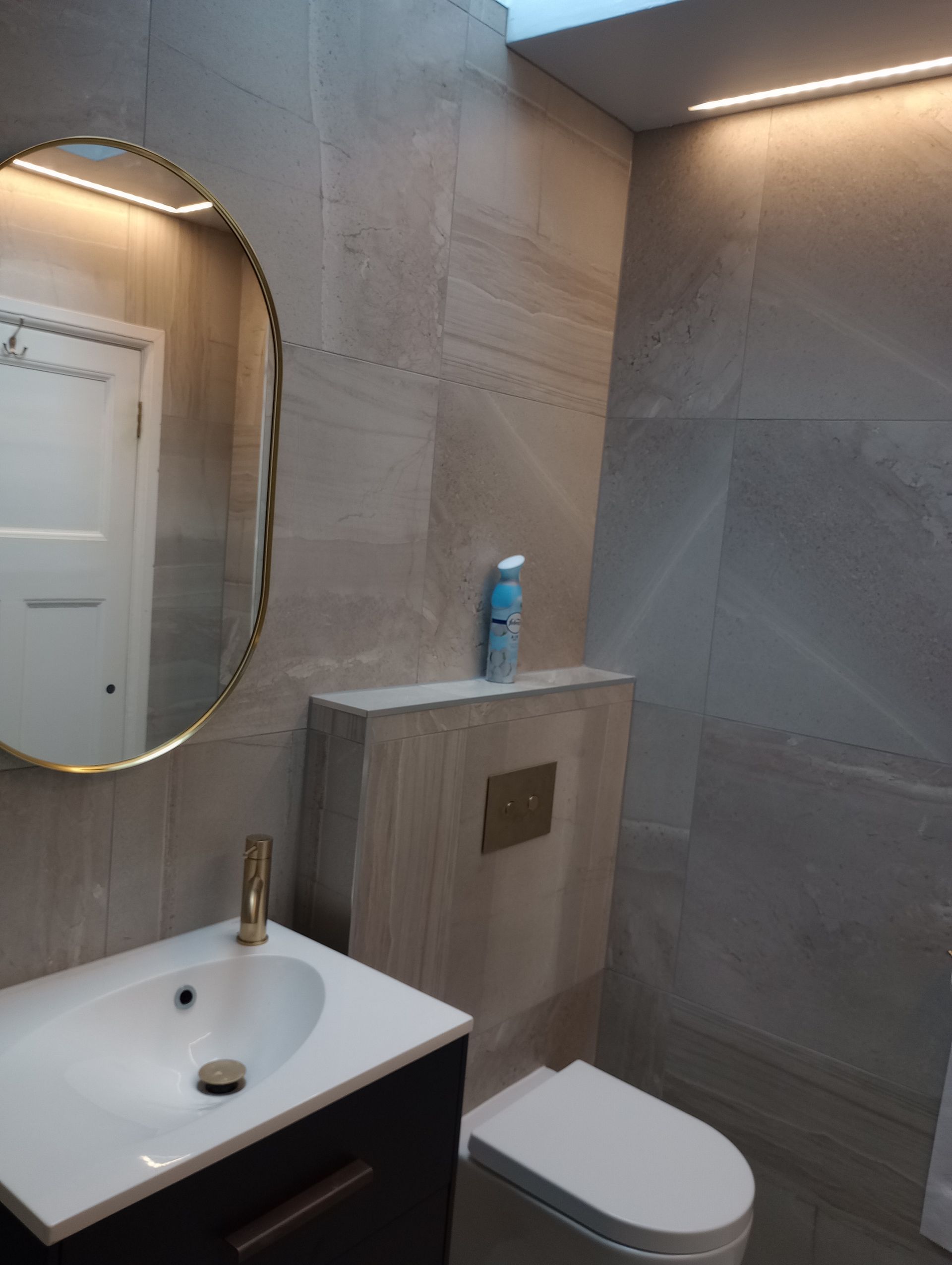 A bathroom with a toilet a sink and a mirror