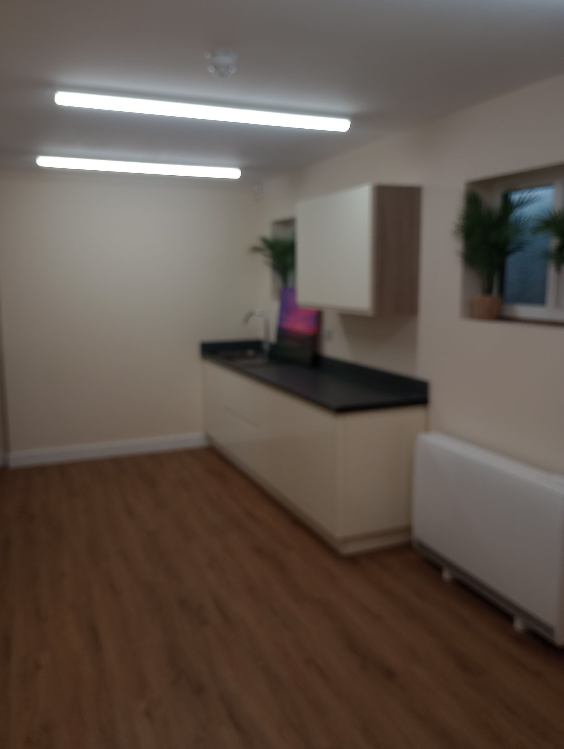 A kitchen with wooden floors and white cabinets