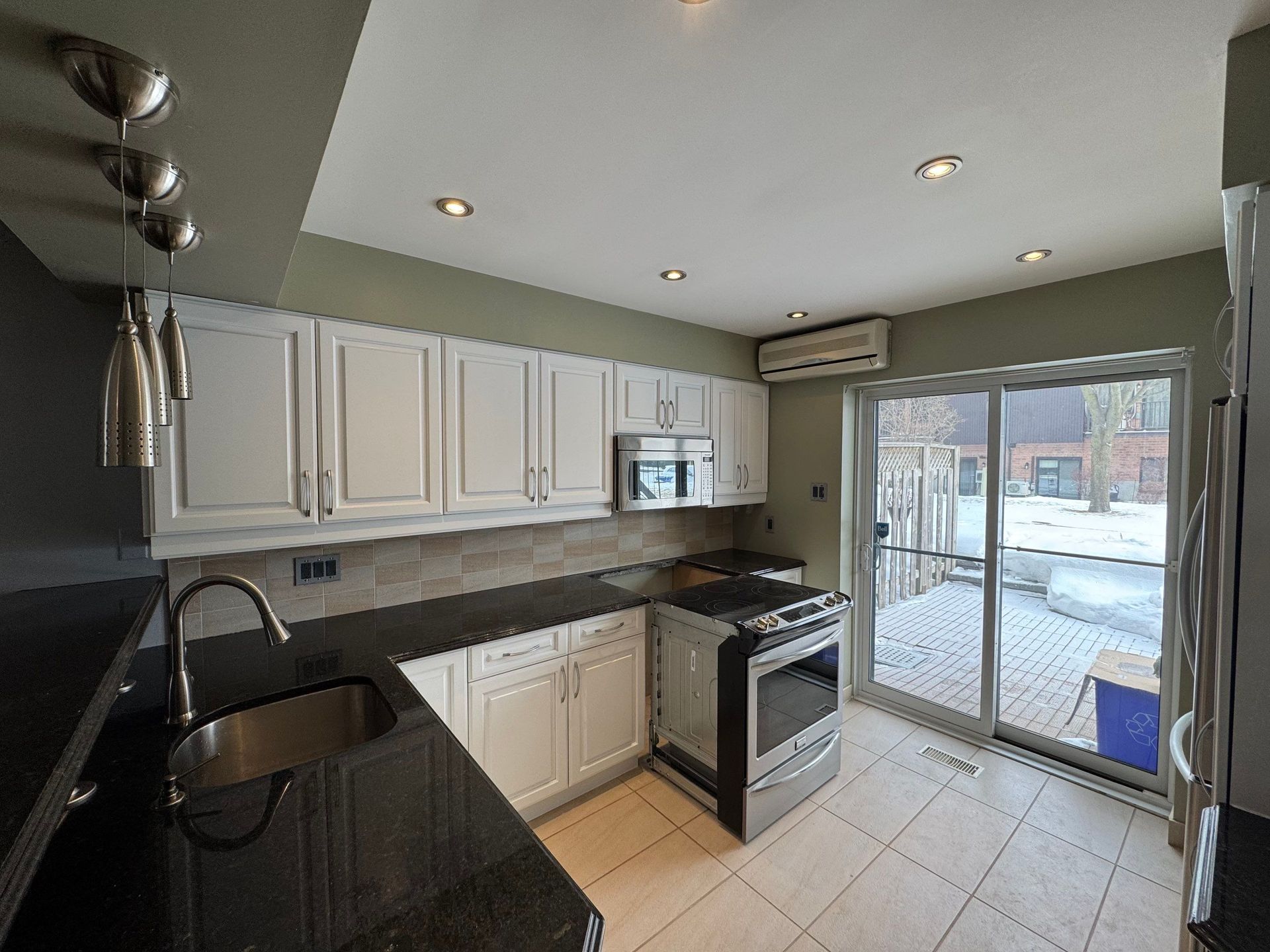 Un salon avec cheminée et un escalier menant à la porte d'entrée.