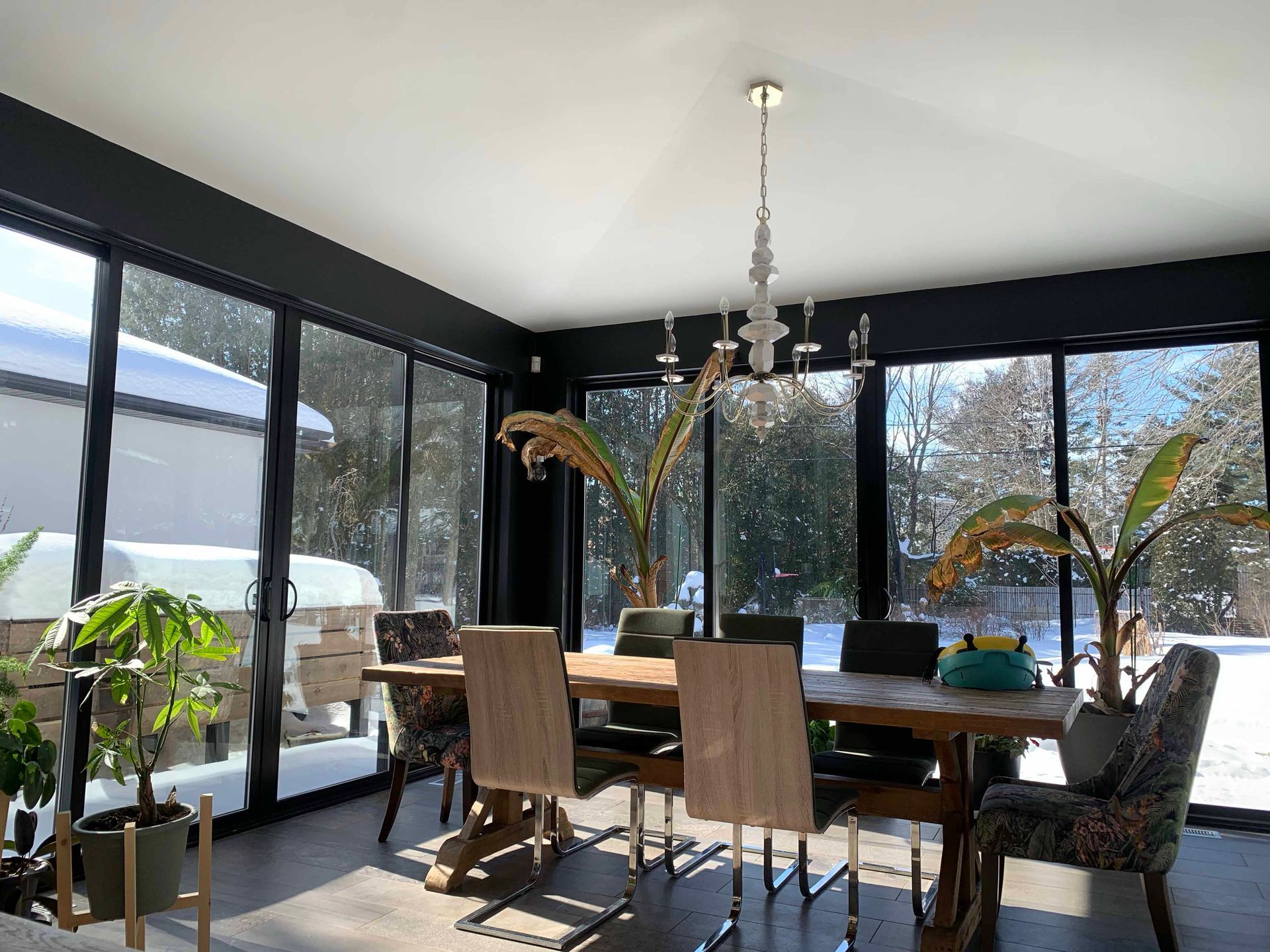 Une salle à manger avec une table et des chaises et beaucoup de fenêtres.