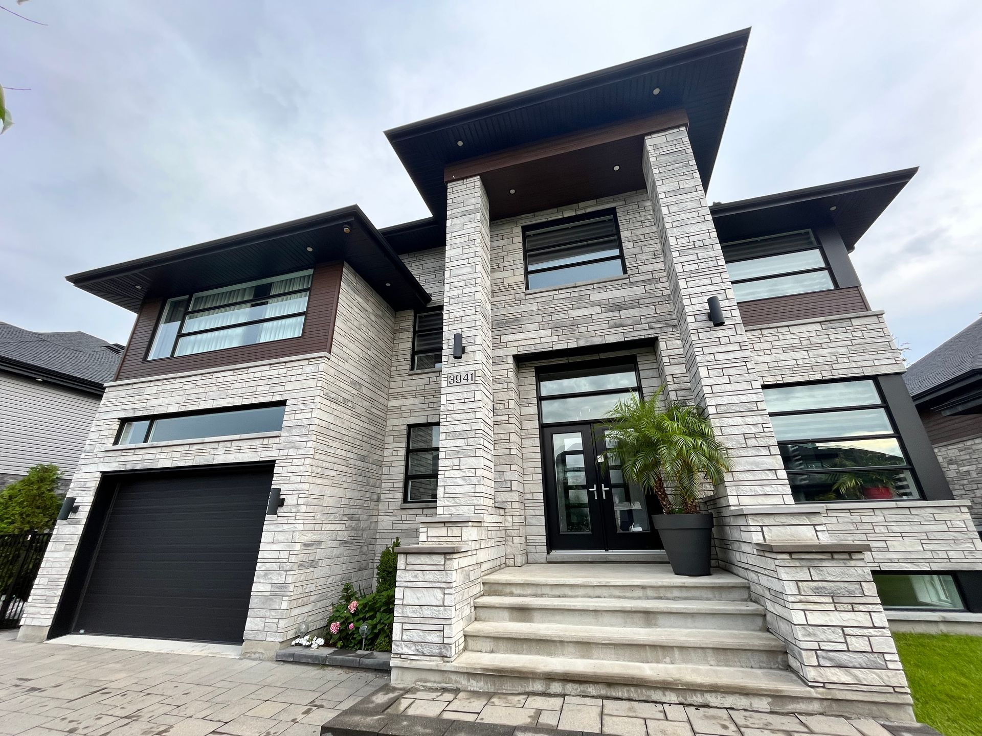 A large white brick house with a black garage door.