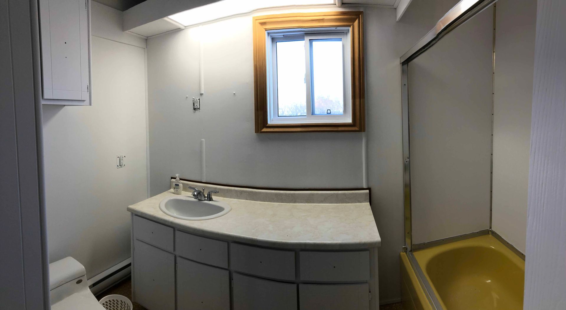 Un salon avec cheminée et un escalier menant à la porte d'entrée.