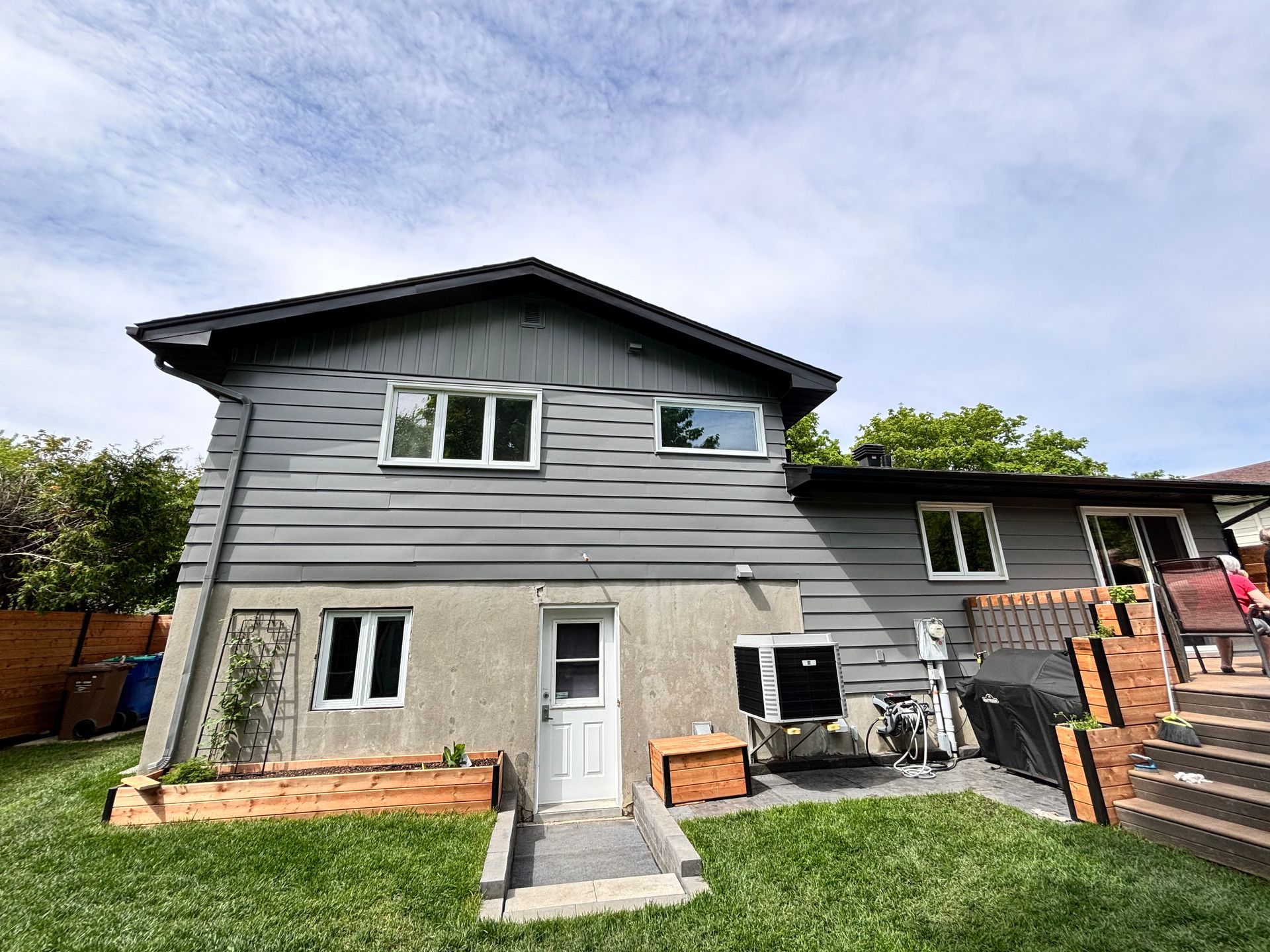 Une petite maison avec un garage et un escalier devant.