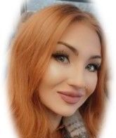 A close up of a woman 's face with red hair and green eyes.
