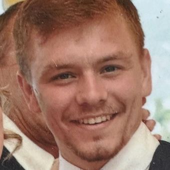 A man in a suit and tie is smiling for the camera.