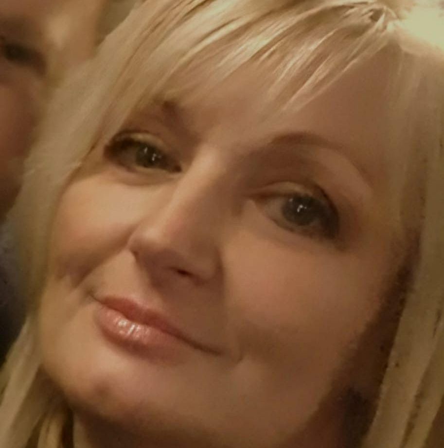 A close up of a woman 's face with a man in the background.