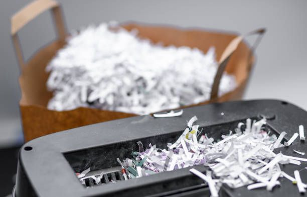 Close-up of a commercial paper shredding process with paper filling a disposable brown bag.