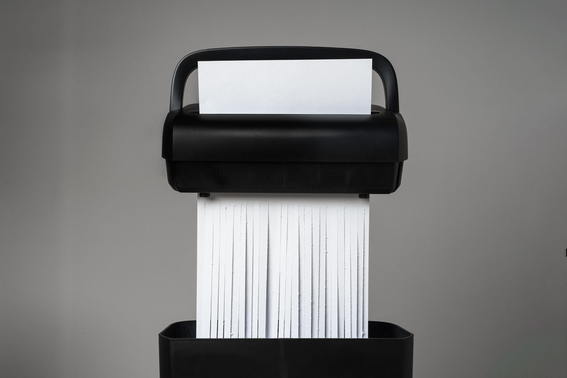 Black paper shredder cutting paper on gray background close up | Indianapolis IN