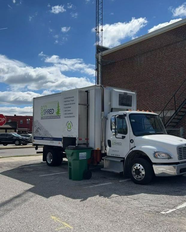 A white truck is parked in a parking lot in front of a building. A white truck is parked in a parking lot in front of a building.