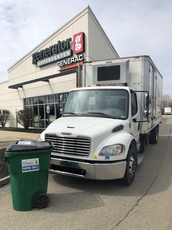 A white truck is parked in front of a generator supercenter