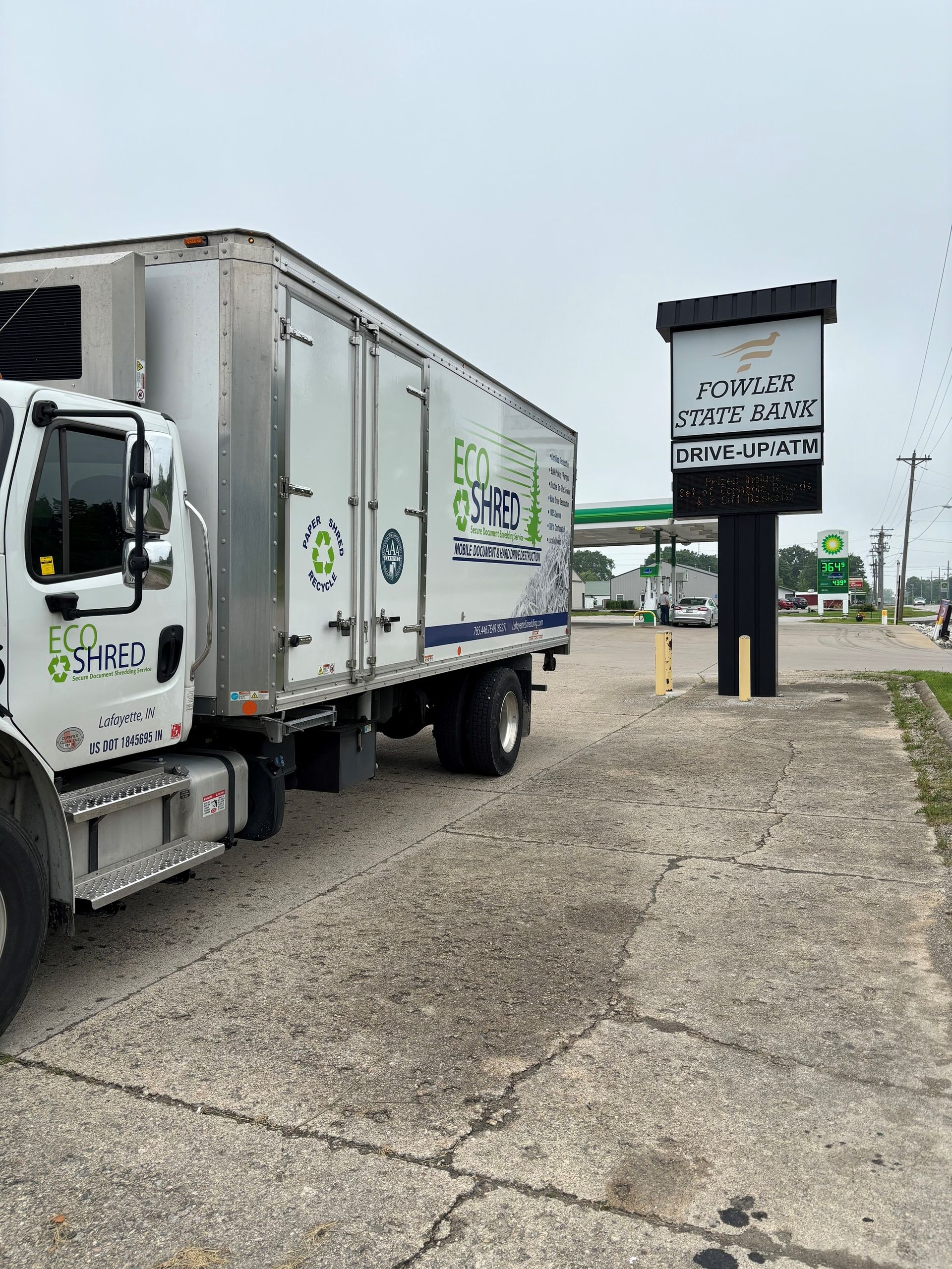 A truck is parked in a parking lot next to a gas station.