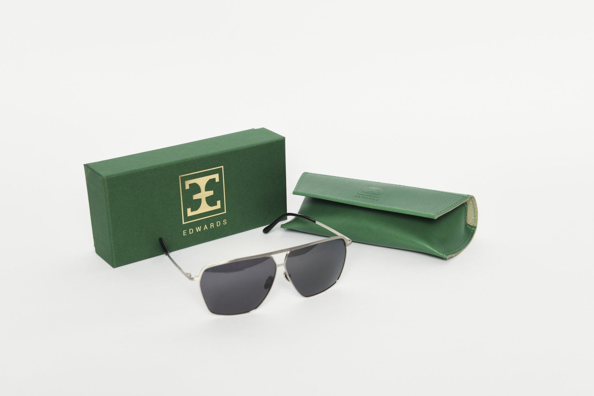Sunglasses with a green box and case on a white background.